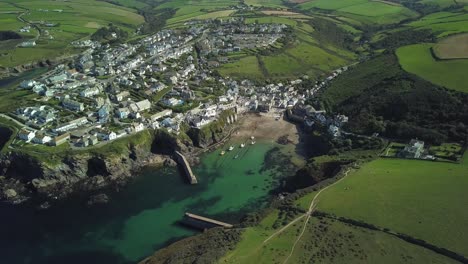 volando sobre los exuberantes campos verdes con una vista panorámica de port isaac y el paseo costero en cornualles, inglaterra, reino unido