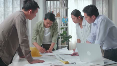 group of asian engineers drawing building construction at the office