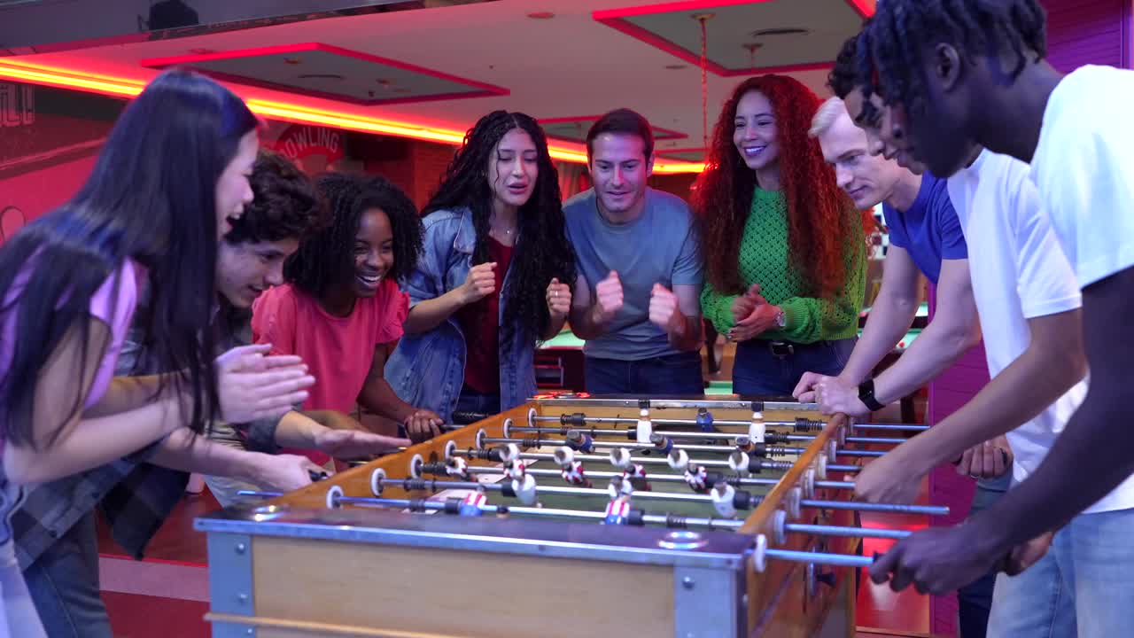 Group of friends playing table football and celebrating