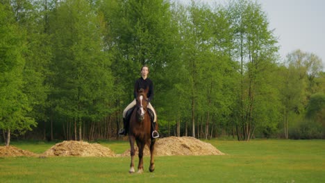 woman horseback riding in a meadow