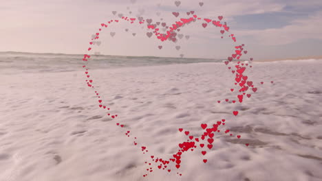 heart-shaped animation of red and pink hearts over ocean waves on beach