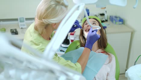 dentist drilling tooth of woman. doctor working with patient in dental clinic