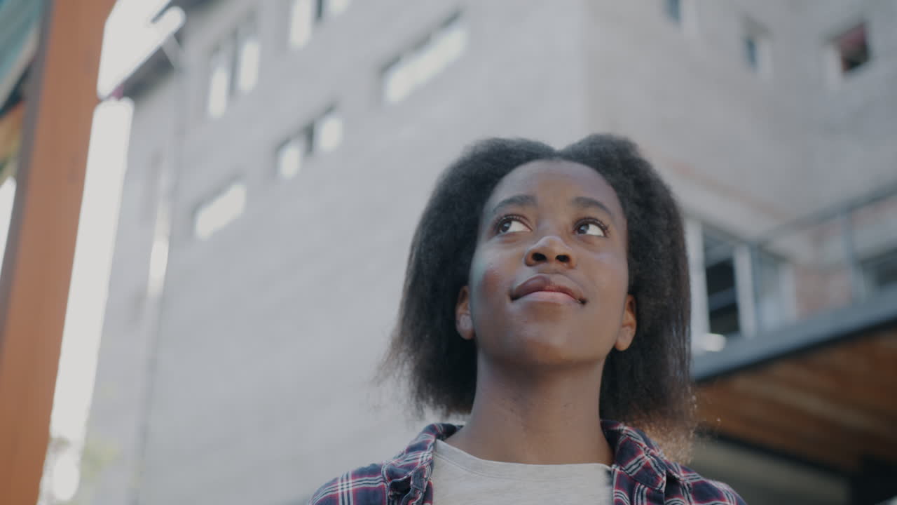 Young Woman Looking Up at a Building