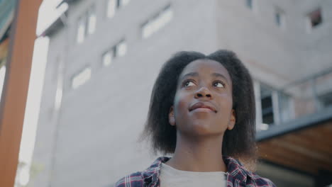 young woman looking up at a building