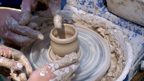 hands of the master potter and vase of clay on the potter's wheel