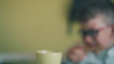 motion past boy with book and child eating pizza at table