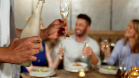 man serving champagne to his friends on dinner table 4k 4k