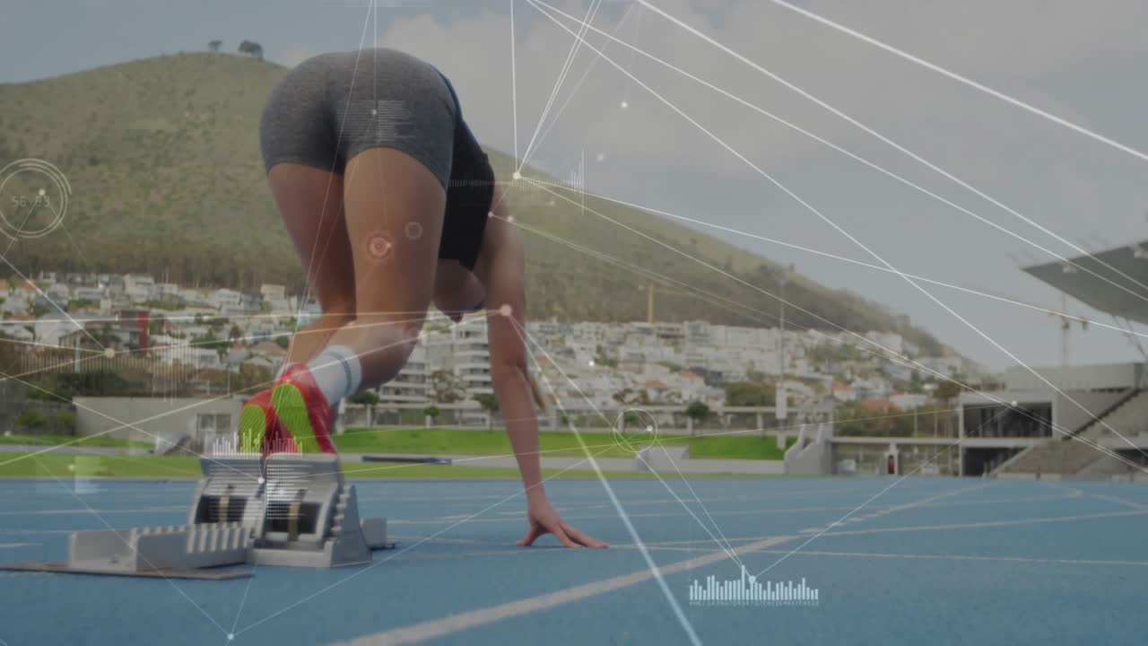 Female athlete pushing through blocks on blue track accelerating after signal with data overlays