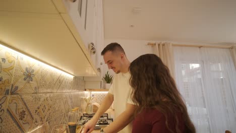 una pareja enamorada haciendo un sándwich en la cocina de la sala de estar