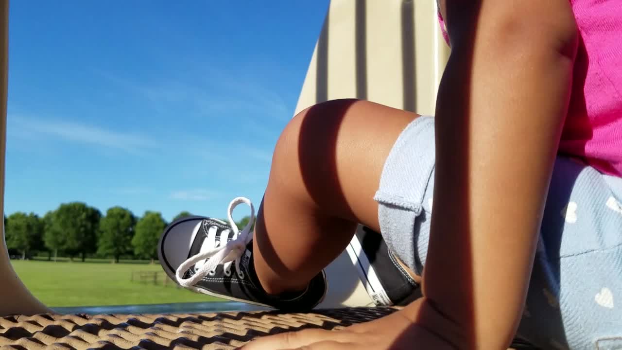 공원에서 미끄럼틀을 타고 내려가는 아프리카계 미국인 소녀