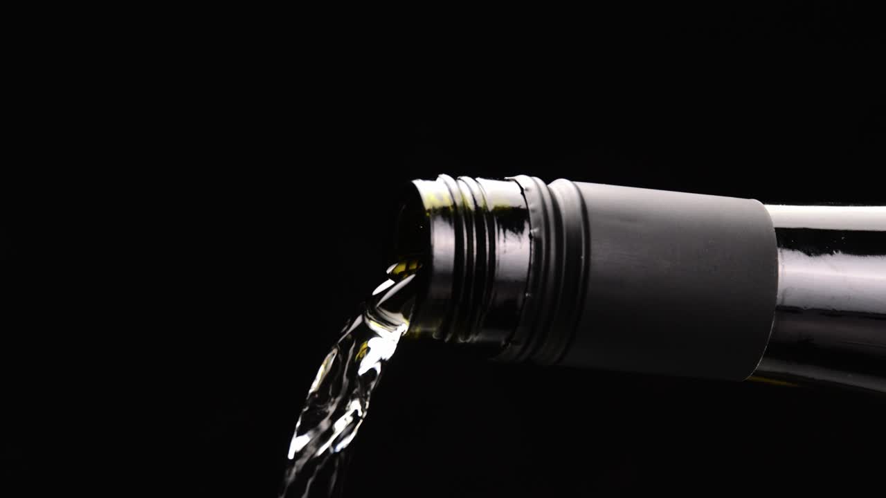 verter vino de oro en una copa de fondo negro