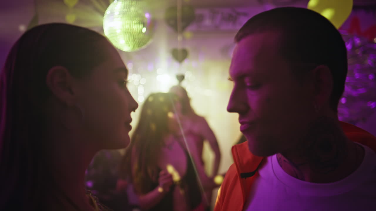 Pair having fun party club with neon lights closeup. Romantic couple dancing