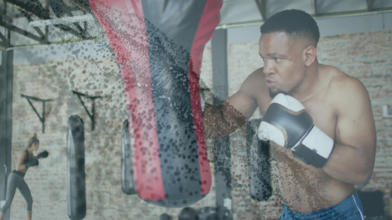 Training with punching bag, boxer surrounded by animation of abstract particles