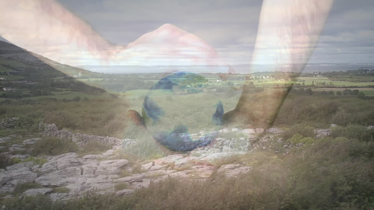Forming heart shape with hands over scenic countryside animation with stone walls