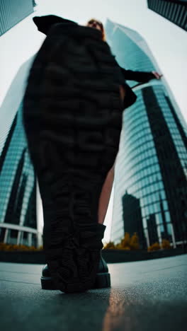 low angle view of a person in black boots walking in an urban setting