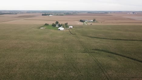 Aerial-drone-view-in-rural-Iowa-with-a-view-of-corn-fields-and-farms-with-barns-and-silos
