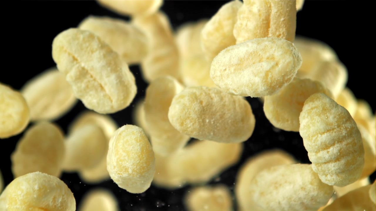Soffietti di mais che cadono al rallentatore su sfondo nero