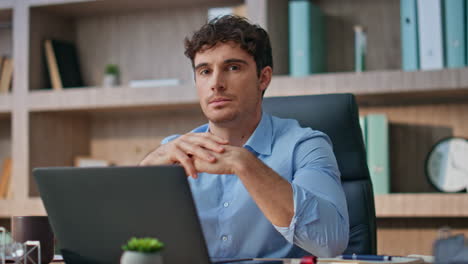 serious boss looking camera in company office. handsome man contemplating idea