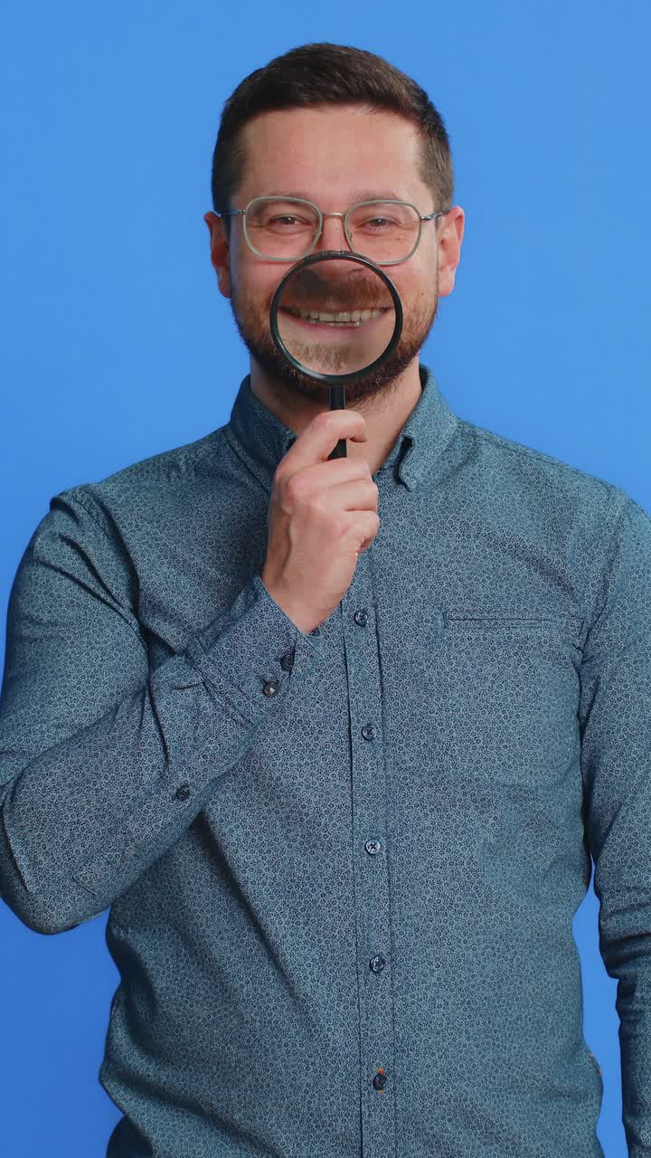 Happy smiling caucasian man holding magnifier glass on teeth health care hygiene stomatology concept