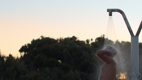 Slow-motion---man-under-a-shower-outdoors