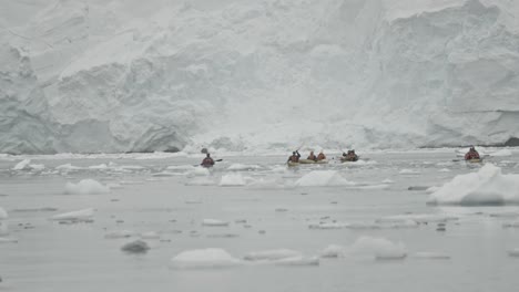 kayak expedition dangerous close to big glacier and ice berg and floats in polar region