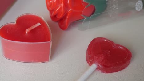 heart-shaped lollipop, candle, and rose as part of valentine's day decorations