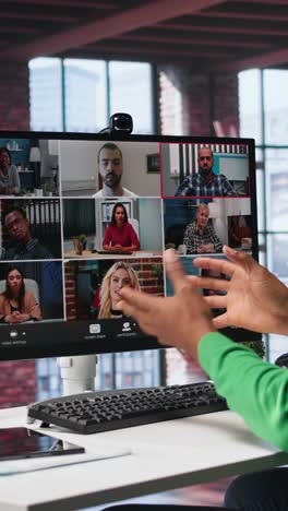 vertical video african american guy at desk is engaged in video call with coworkers