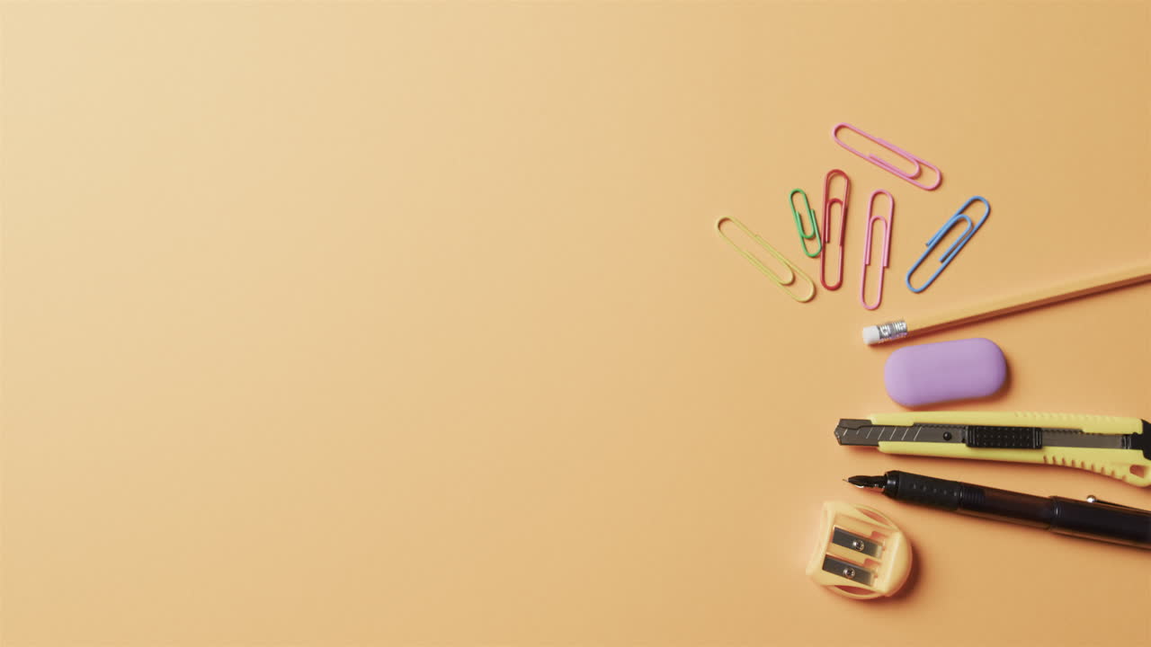 vista aérea de la papelería escolar colorida con espacio de copia sobre fondo beige, en cámara lenta