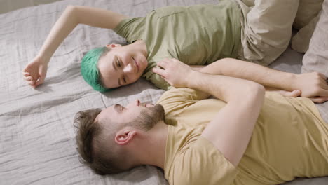 top view of a loving couple hugging and cuddling while lying on the bed