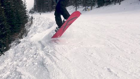 Snowboarder-drops-in-to-dip-hits-lip-and-jumps-out-of-frame-then-back-into-frame-close-up