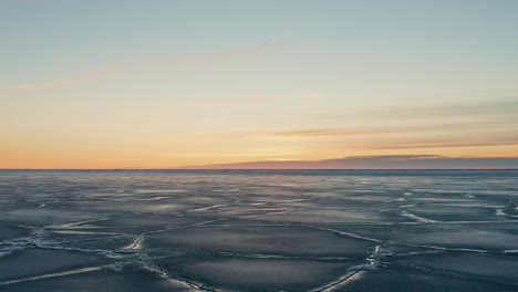 Lento-Movimiento-Hacia-Atrás-Sobre-Un-Gran-Campo-De-Hielo-Agrietado-Y-Agua-Visible-En-La-Costa-Del-Mar-Báltico-Durante-El-Invierno