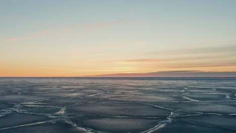 lento movimiento hacia atrás sobre un gran campo de hielo agrietado y agua visible en la costa del mar báltico durante el invierno