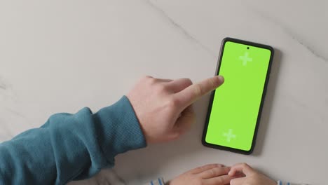 toma de estudio aérea de padre e hijo usando un teléfono móvil de pantalla verde juntos 1