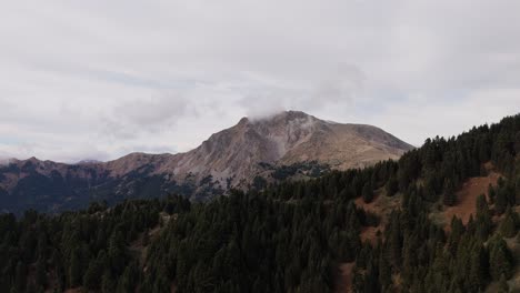 Panoramic-aerial-establish-to-exposed-grey-brown-rock-of-mountains-by-Agrafa-Greece-at-beautiful-overcast-day