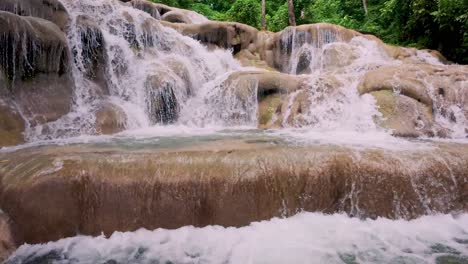 close up view of dunn’s river falls in jamaica, showcasing cascading water through lush tropical forest.