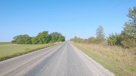 pov while driving on a county paved road in rural iowa in early autumn