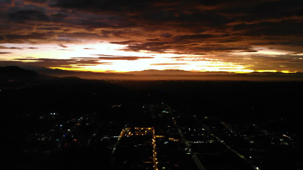 puesta de sol ardiente sobre la ciudad de salento en colombia por la noche, 4k aéreo, escena oscura