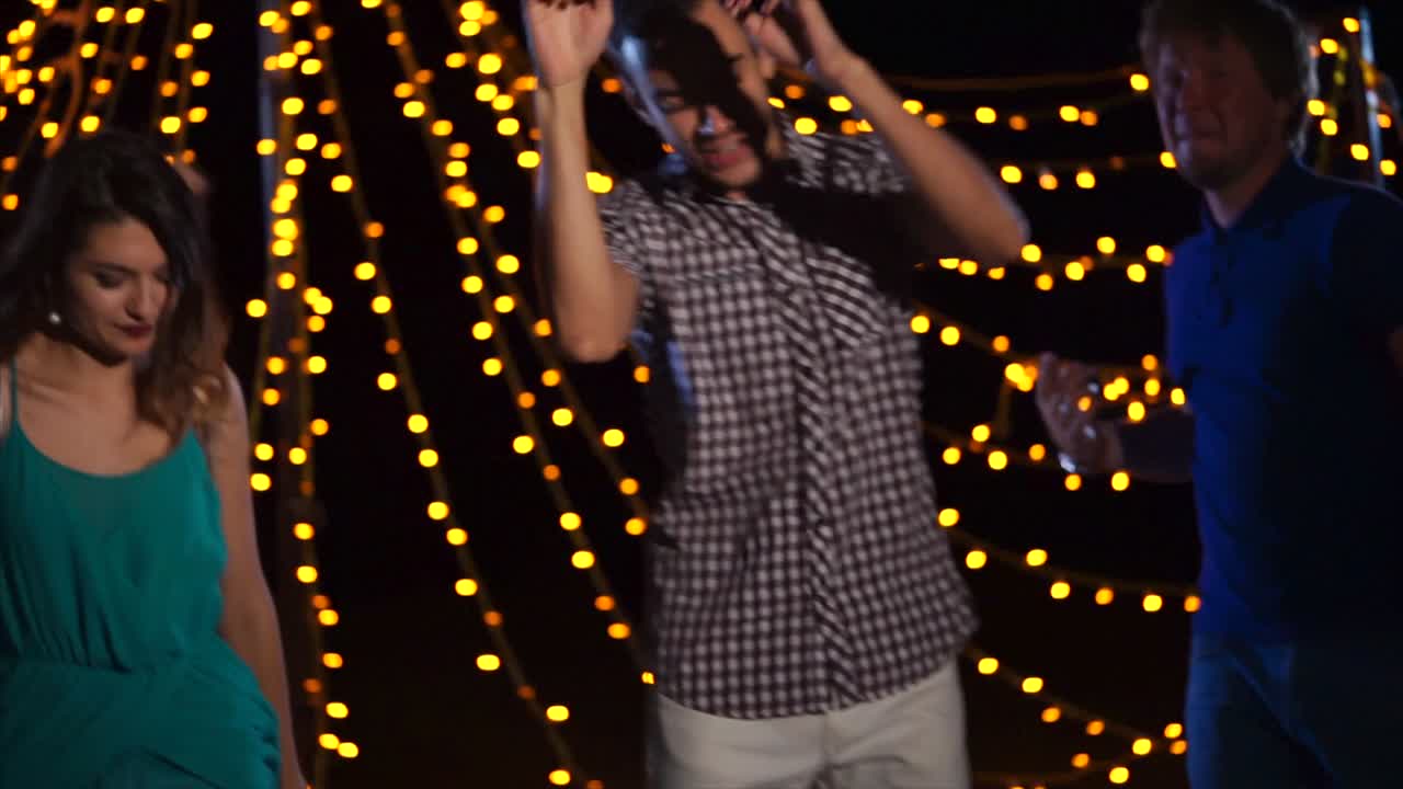 Friends Dancing Under String Lights