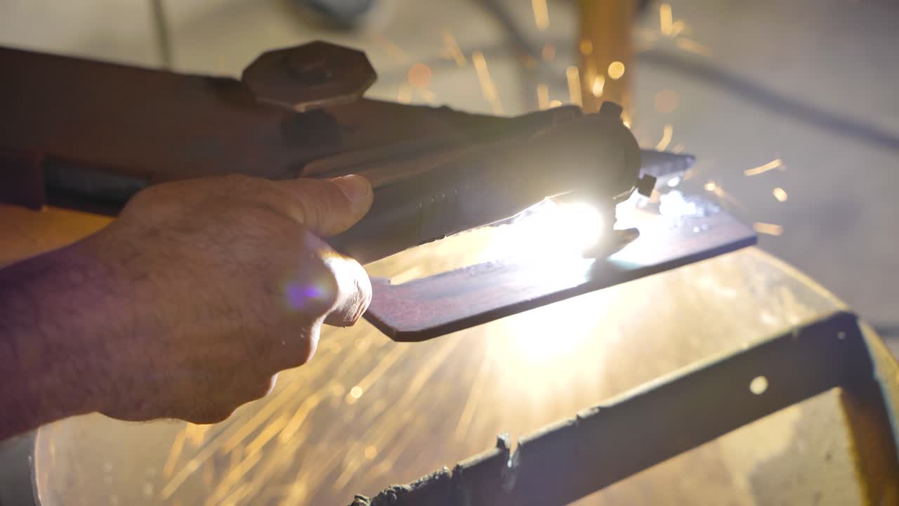 Close up of a man plasma cuts a piece of metal