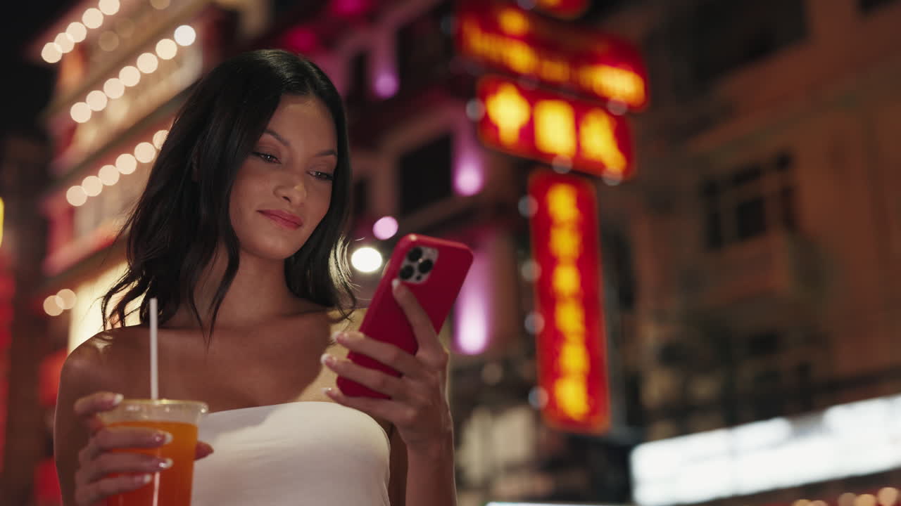 Donna che usa lo smartphone in una vivace città asiatica di notte
