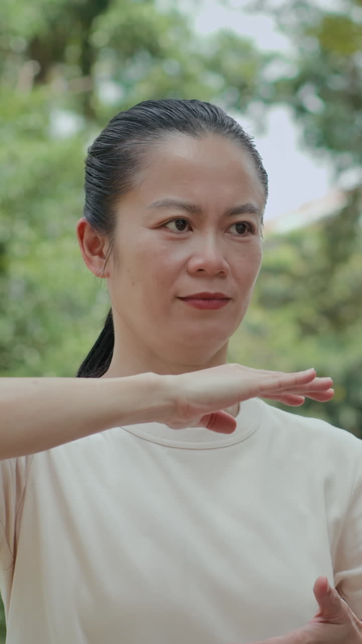 Asian Sportswoman Practicing Tai Chi Moves Outdoors