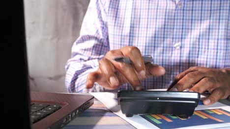 hombre de negocios trabajando en documentos, calculadora y portátil