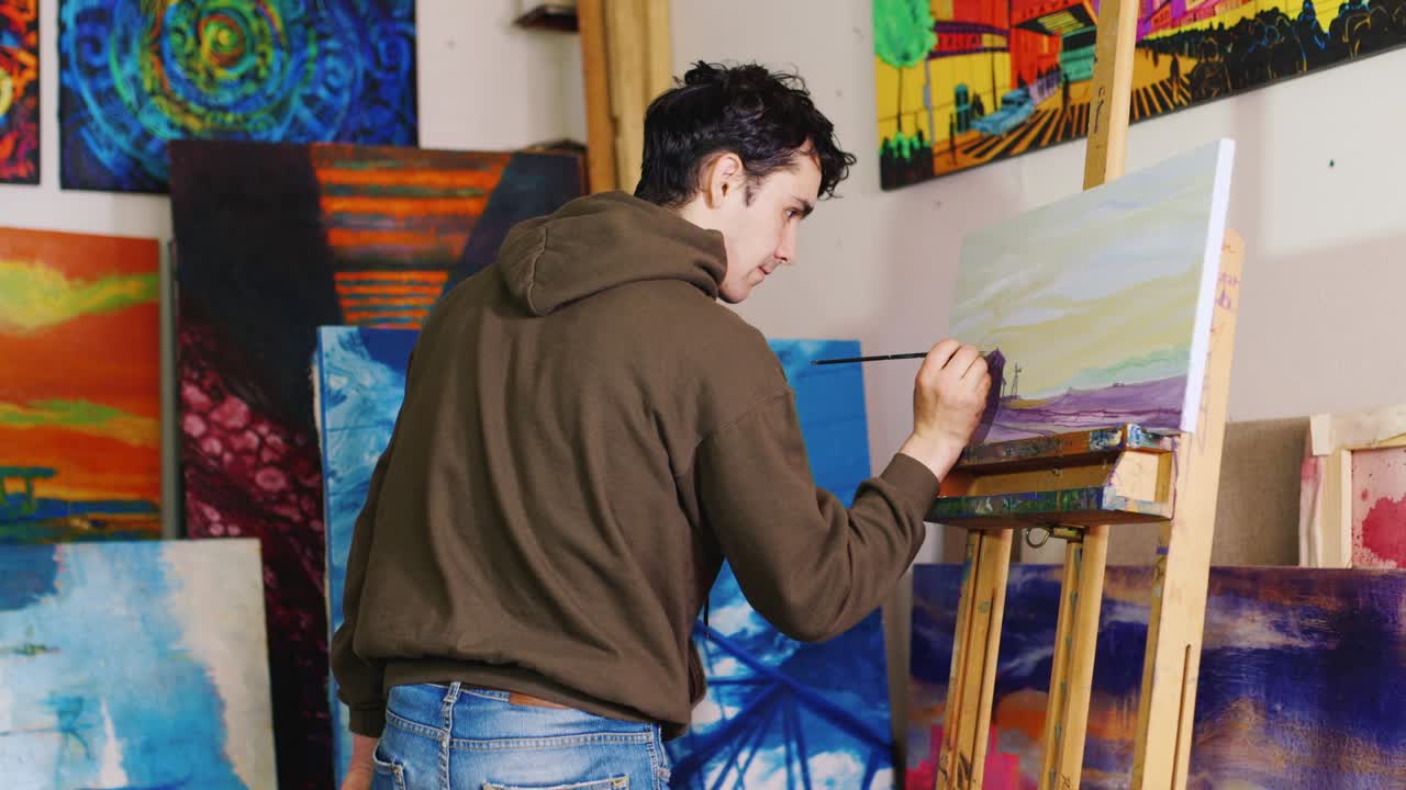 Trabajando en el estudio creativo del pintor. Joven artista mestiza pinta un cuadro.