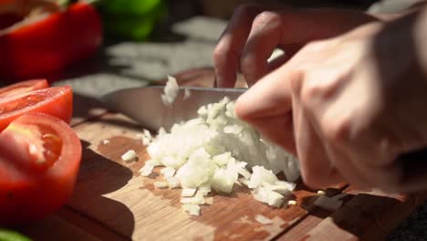 person slicing white onion in small dice