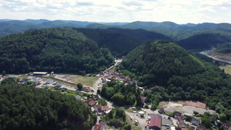 vista aérea de un pueblo ubicado en un valle rodeado de montañas y bosques.