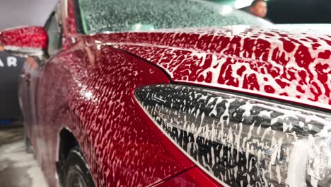 red car getting washed with foam