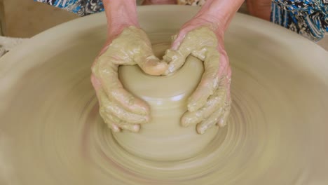 Hallow-hole-shaping-clay-pot-on-electric-potters-wheel