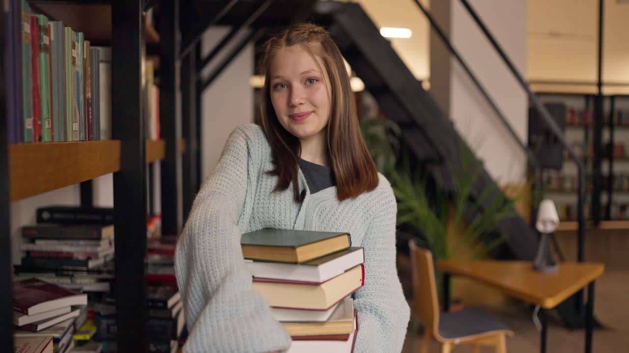 Ragazza adolescente in biblioteca con dei libri in mano