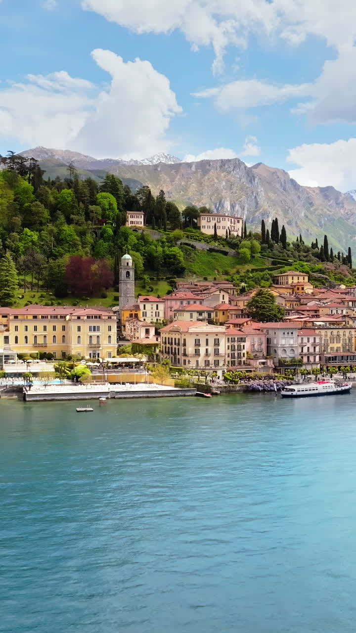 Aerial drone view of the Basilica of St. Giacomo surrounded by houses in Bellagio, Italy. Vertical