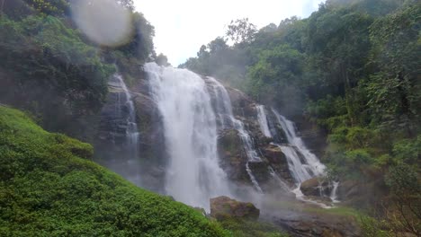 vista dinámica de la impresionante cascada en la exuberante jungla con lentes que golpean el agua